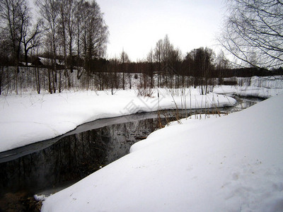 解冻冬季森林中的小河图片