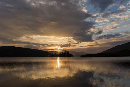 日落在湖面上反映山岳云和太阳橙色图片