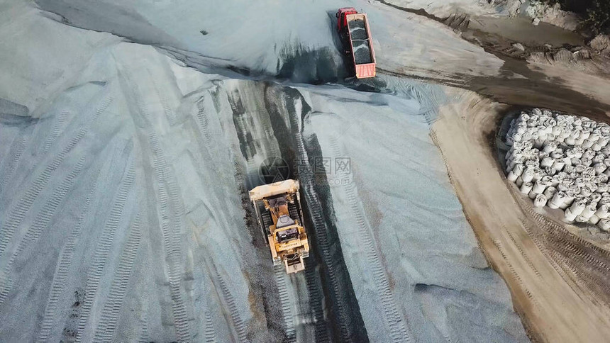 重型机械挖掘机和卡车的顶视图正在采砂场工作在采石场工作的商业用地和图片