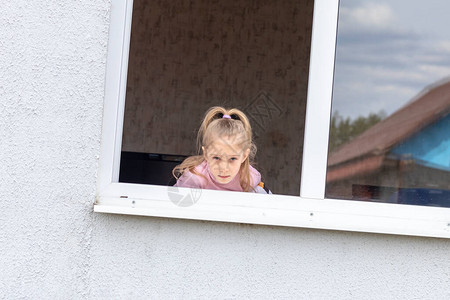 孩子坐在窗户的低潮下图片