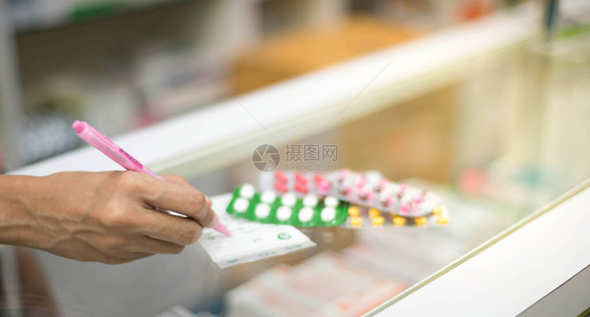 女药剂师准备药胶囊包药房卖给病人在药店保护对图片