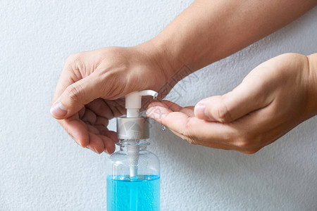 在泵瓶清洗抗细菌污染皮肤护理中使用酒精凝胶洗手液的手图像图片