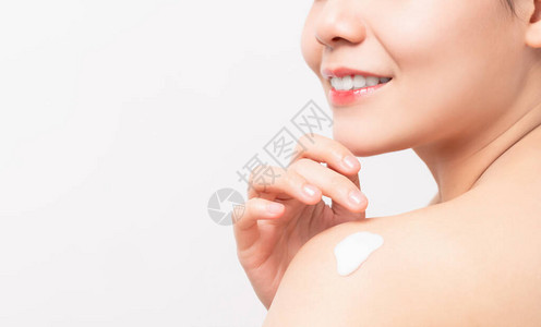 紧贴着微笑的亚洲女手握住并肩膀上施润滑剂全身乳图片