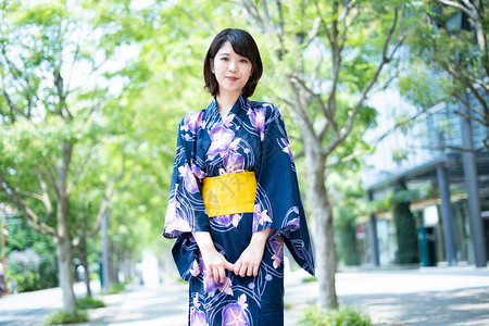 盛夏价到亚裔日语妇女穿着日本传统服装到城背景