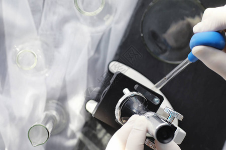 生化学家实验室研究药物测试在实验室进行化学实验在医务人员的桌子上用显微镜观察各背景