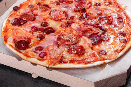 意大利辣香肠披萨配马苏里拉奶酪意大利腊肠西红柿胡椒和香料图片