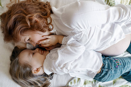 母亲的女儿时刻孕妇与女儿一起躺在床图片