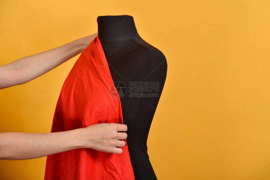 女人在黑色人体模型上试穿红色大布图片