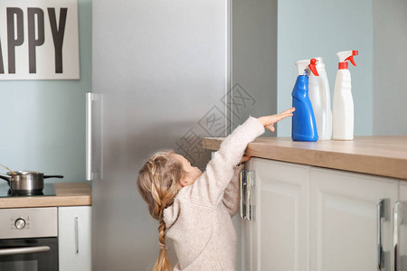 小女孩试图在家里伸手去拿瓶装洗涤剂图片