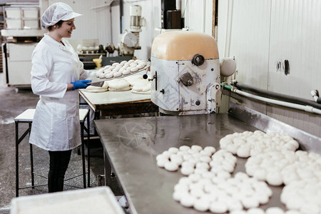 年轻女工在大型面包店工作图片