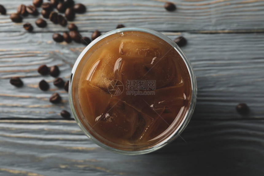 木制背景上的一杯冰咖啡咖啡种子图片