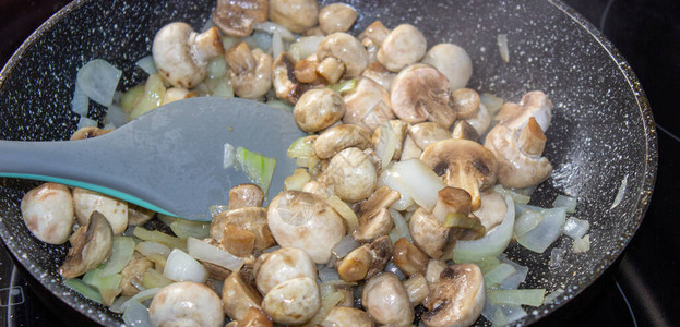 煎锅里有洋葱的蘑菇准图片