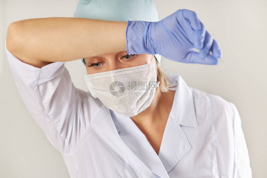 一名戴医疗面具和手套的妇女用手擦图片