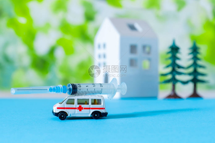 带有针筒白房子和树木的玩具救护车在标志医院附近图片