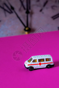 玩具救护车和粉红色背景的老旧手图片