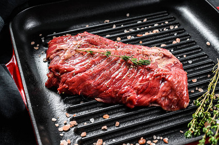 烤锅上的顶尖刀片牛排生肉大理石牛肉黑色背图片