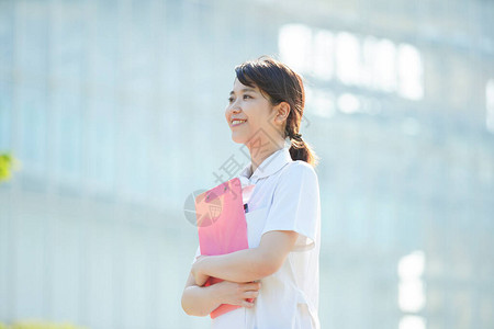一名亚洲日语女护士在户外露背景图片