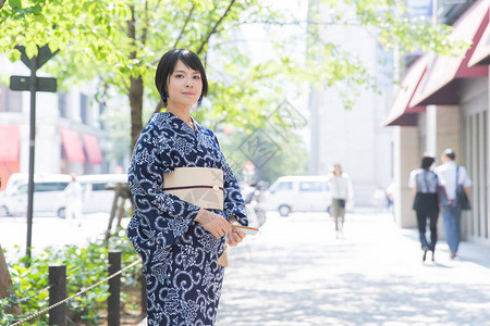 亚裔日语妇女穿着日本传统服装到城背景图片