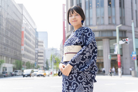 盛夏价到亚裔日语妇女穿着日本传统服装到城背景