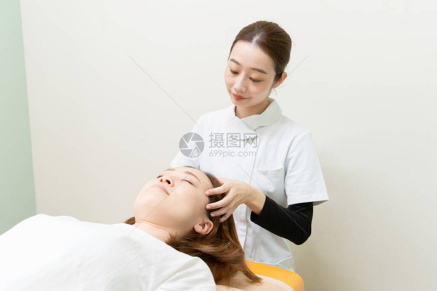 亚洲女执业医师对女患者的头部和图片