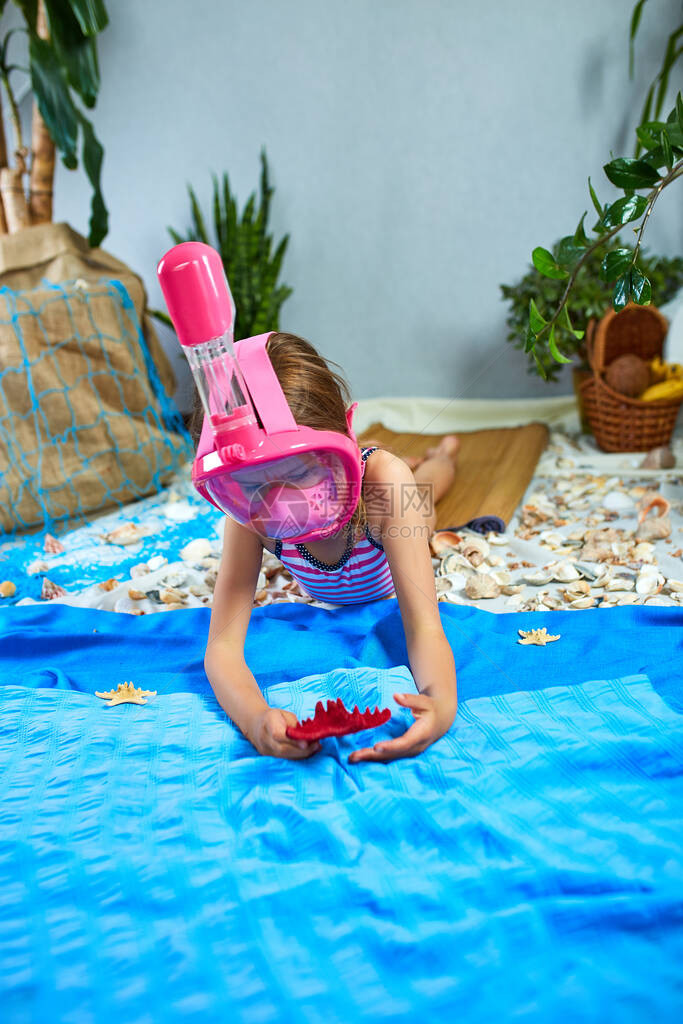 戴着浮潜面罩的小女孩在家隔离时模仿在虚构的大海或滩附近的海洋中游泳图片