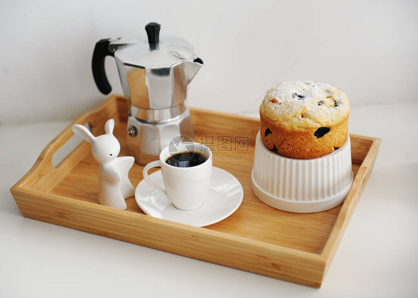 咖啡和纸杯蛋糕在木竹盘中供应图片