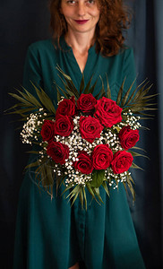 女人拿着红色玫瑰的花图片
