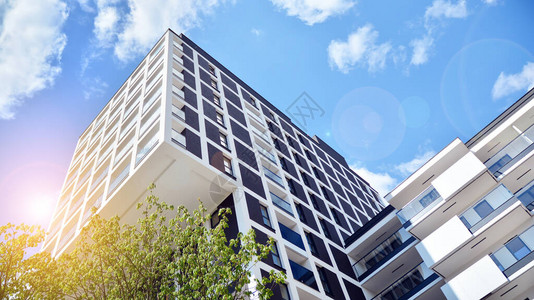现代公寓楼在晴朗的一天与蓝天现代公寓楼的门面有阳图片