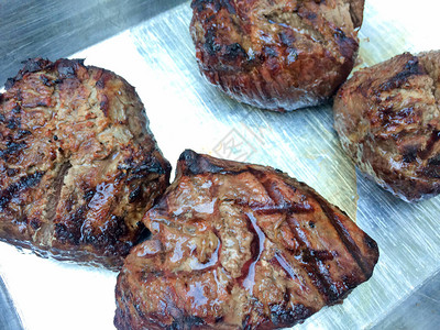 银色背景盘上的菲力牛排烤多汁牛肉图片