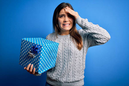 年轻的金发女郎拿着一个礼品盒作为生日礼物图片