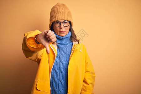 中年妇女穿着黄色雨衣和冬帽图片