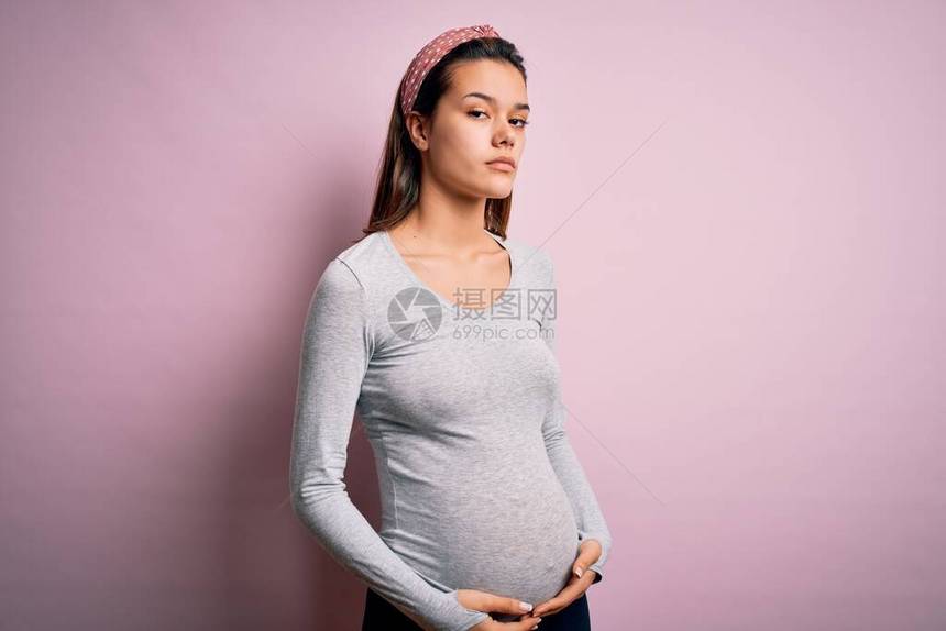 年轻漂亮的少女怀孕在孤立的粉红色背景下怀孕图片