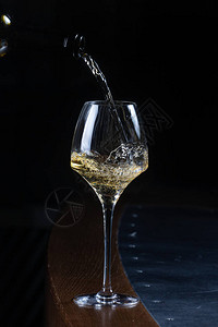 将白葡萄酒倒入酒吧的玻璃杯中图片