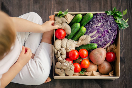 在为家庭准备的纸箱中提供新鲜和健康的蔬菜以木材背景对健康素食图片