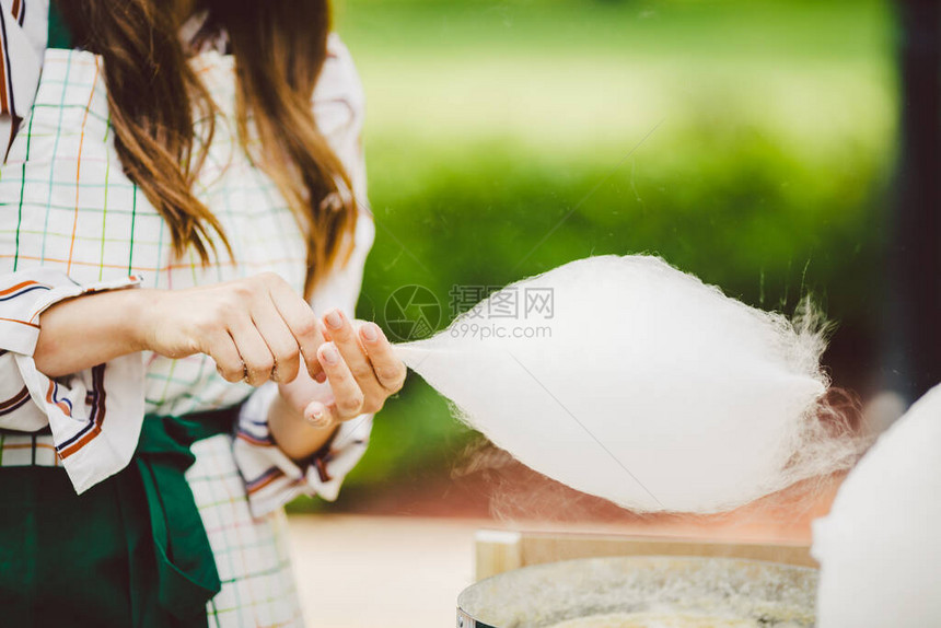 主题是一个家庭小企业烹饪糖果手特写年轻女商人在夏天在公园里制作棉花糖棉图片