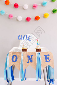 生日庆祝的节日背景装饰字母在婴儿生日的小纸杯蛋糕中发短信给一根蜡烛背景上的花环装饰蛋背景图片