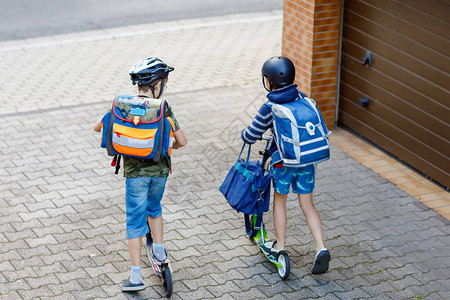 快乐的孩子们穿着五颜六色的衣服在去学校的路上骑自行图片