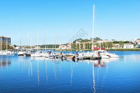 白色游艇和船只在夏季欧洲一个小城市的码头附近站立图片