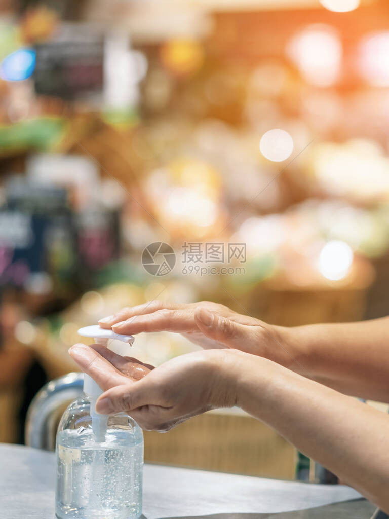 妇女用明确的酒精凝胶瓶洗手图片