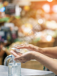 妇女用明确的酒精凝胶瓶洗手图片