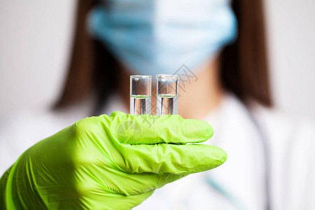 一名持有疫苗测试管的图片