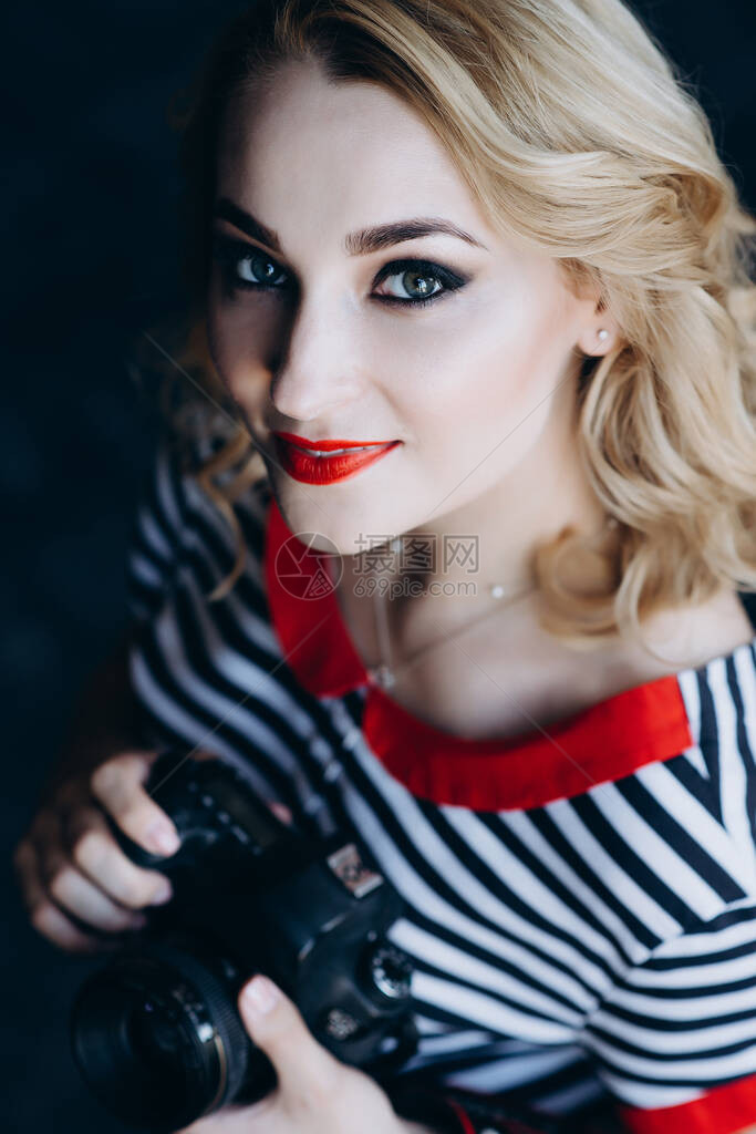年轻漂亮的女孩摄影师在摄影棚里手拿着相机女工作是一种爱好软选择焦点图片