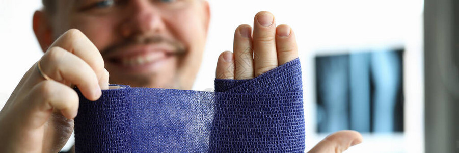 微笑的人用绷带拉伤他的手绷带用于腕关节的营养不良和炎症过程在炎症过程中肌腱图片