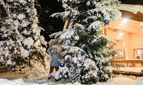 灰色帽子和一件蓝色夹克与白色靴子在美丽的冬季景观的背景上的女孩卡图片