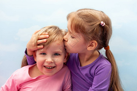笑着孩子们亲吻头部的概念家庭童年概念中的关怀和图片