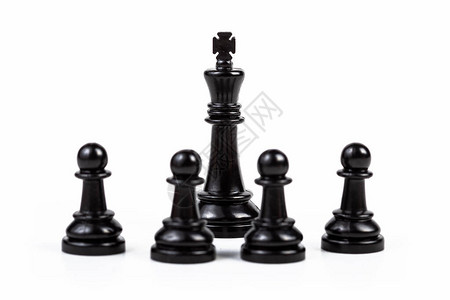 被四个棋子包围的黑色国王棋子高清图片