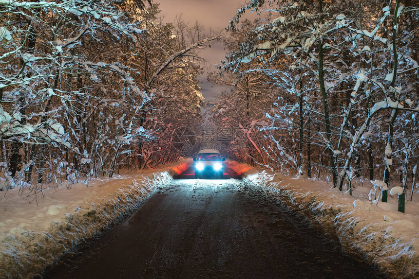 在积雪的寄养路上的汽车晚上时间图片