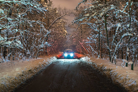 在积雪的寄养路上的汽车晚上时间图片