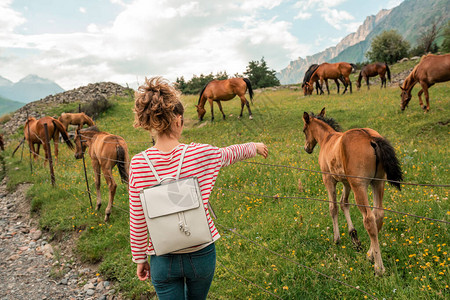 在山自然的背景下关闭了有马的女孩幸福的女人与动物马友谊动物和图片