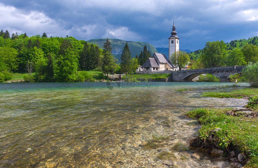 迷人的施洗者圣约翰教堂位于斯洛文尼亚最大的永久湖泊朱利安阿尔卑斯山的博希尼湖上美丽的春天色彩清澈的海水图片